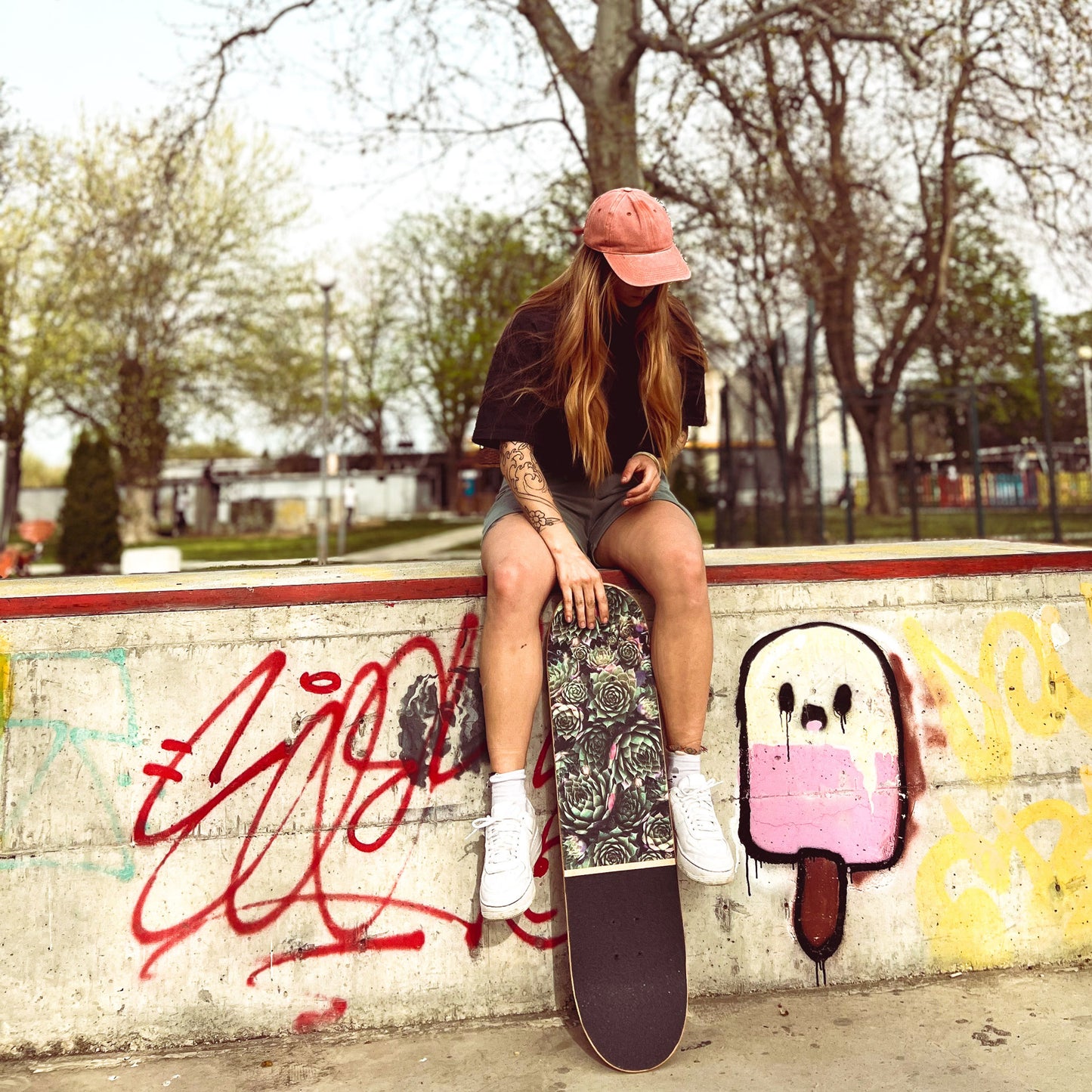 Mädchen sitzt mit dem BTFL Skateboard komplett im Skatepark