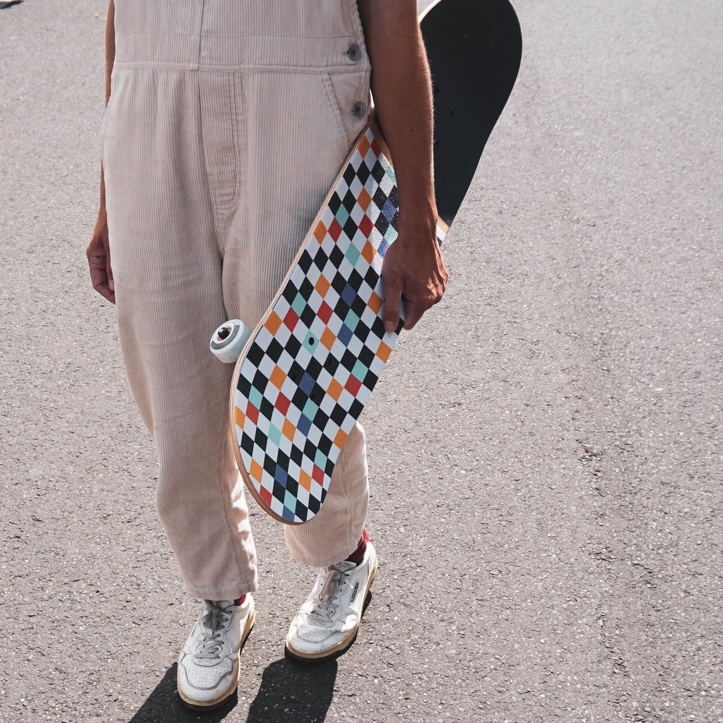 Eine Frau hält das BTFL komplett Skateboard unterm Arm