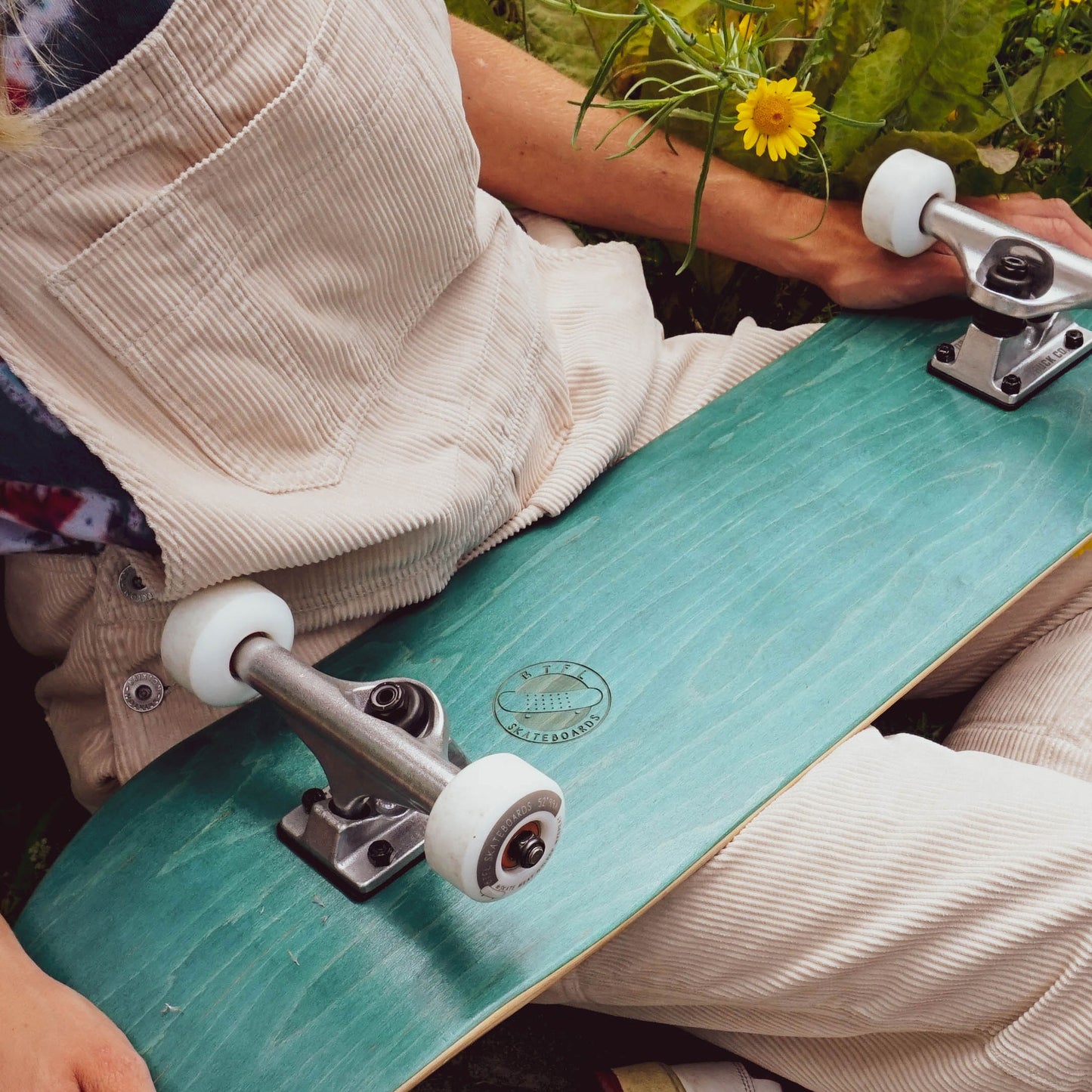 Eine Frau hält ein Komplett Skateboard in den Händen