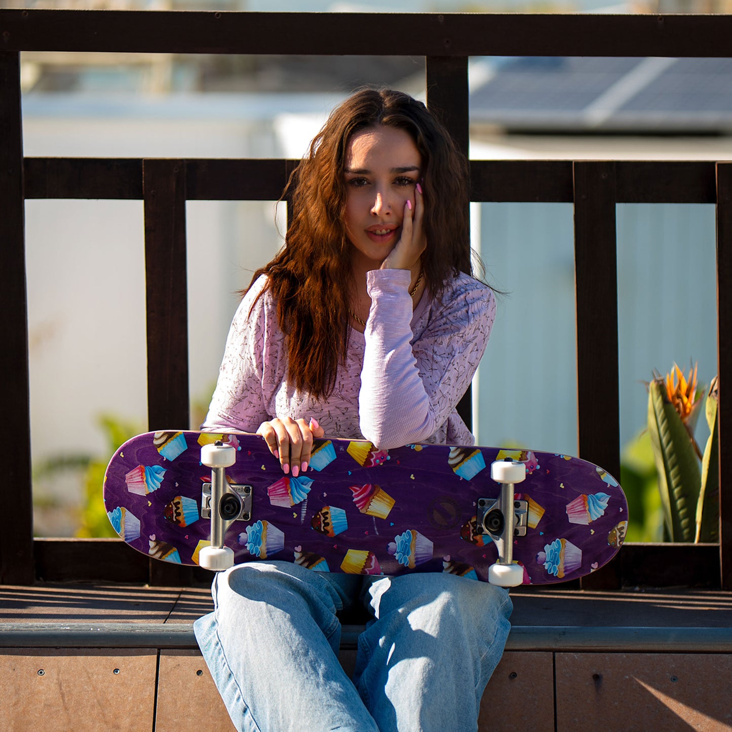 Mädchen hält das BTFL Skateboard Cupcakes komplett auf dem Schoß